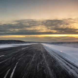 Airport runway in the Far North at dawn surrounded by snow